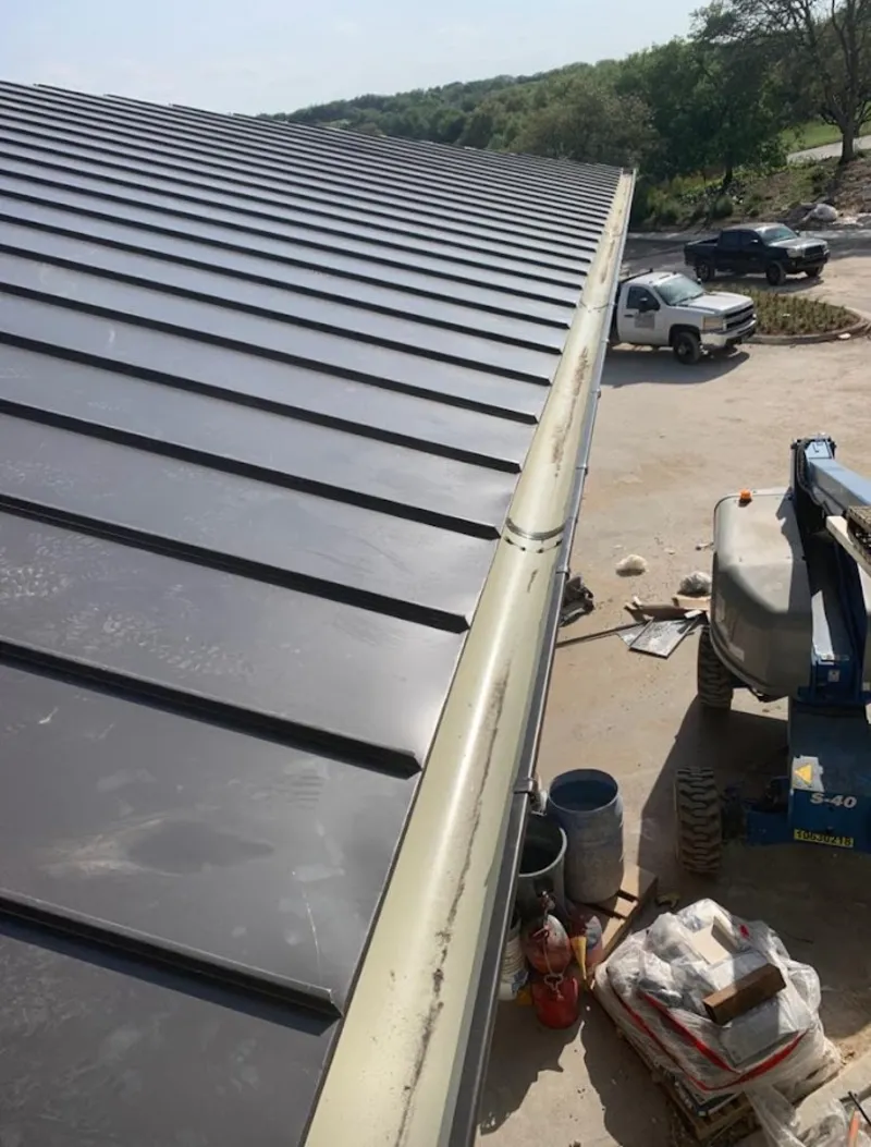 Standing seam panel and gutter detail on a metal roofing jobsite in Avondale